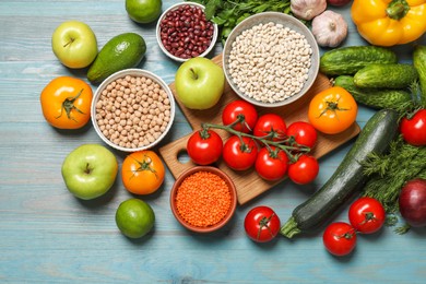 Different vegetarian products on light blue wooden table, top view