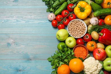 Photo of Different vegetarian products on light blue wooden table, top view. Space for text