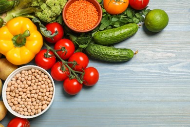 Photo of Different vegetarian products on light blue wooden table, top view. Space for text