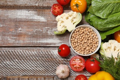 Different vegetarian products on wooden table, top view. Space for text