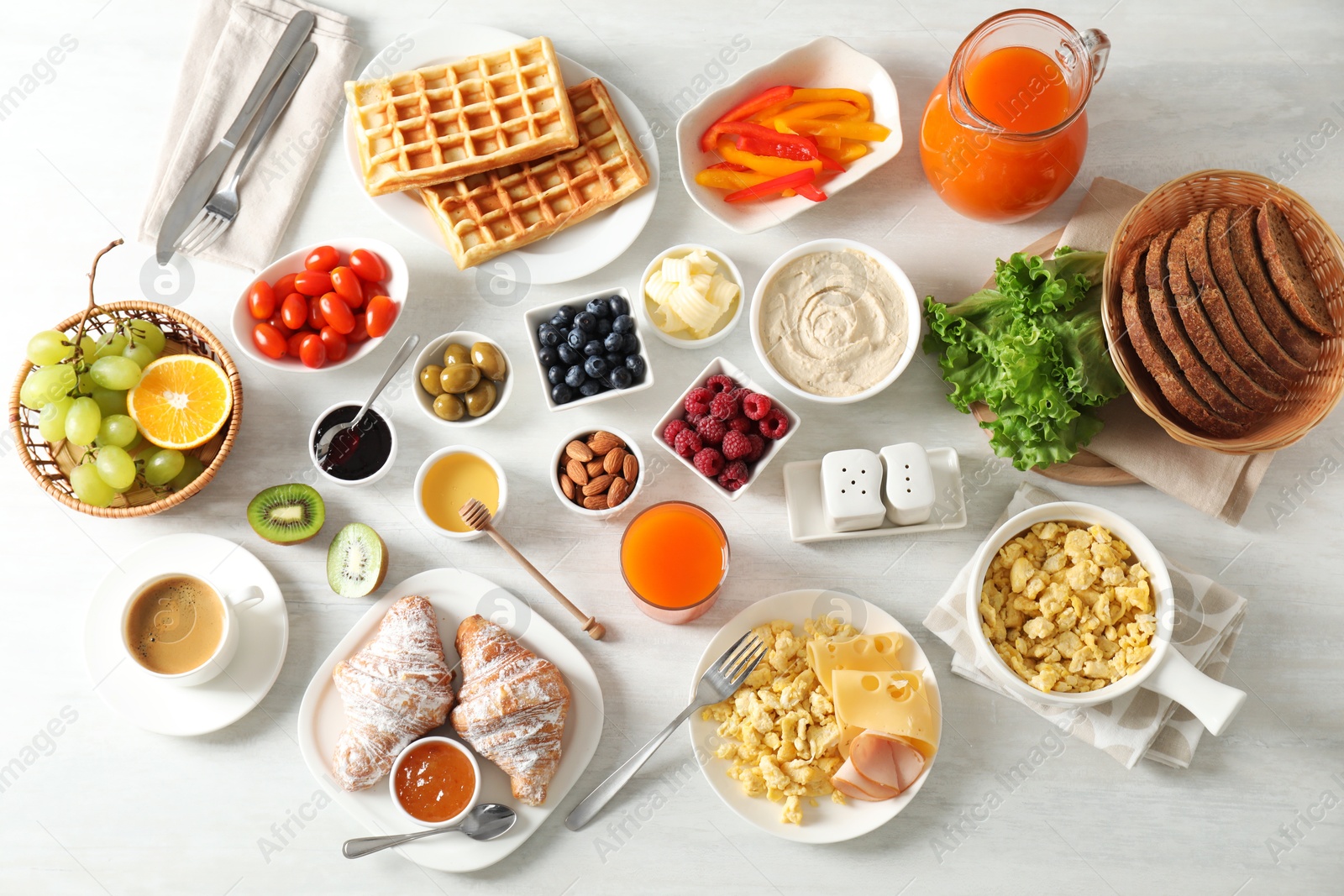 Photo of Tasty breakfast. Flat lay composition with many different food and juice on light wooden table