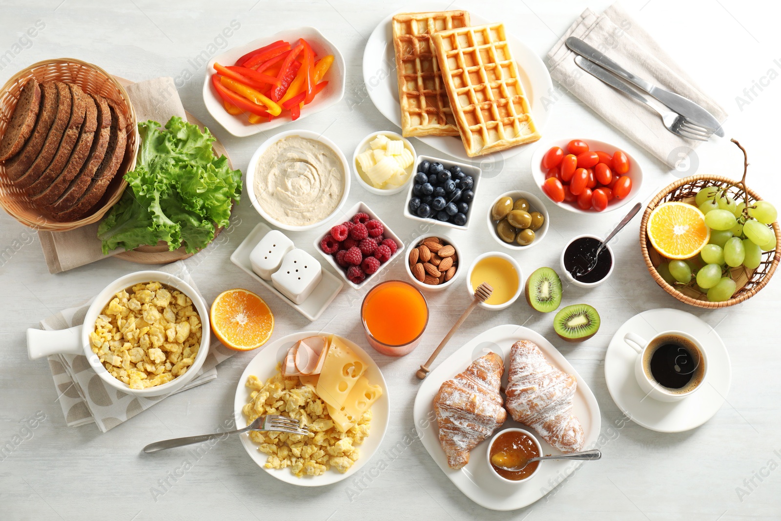 Photo of Tasty breakfast. Flat lay composition with many different food and drinks on light wooden table