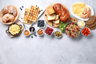 Tasty breakfast. Flat lay composition with many different food on grey textured table. Space for text