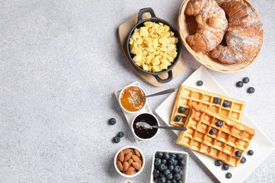 Tasty breakfast. Flat lay composition with many different food on grey textured table. Space for text