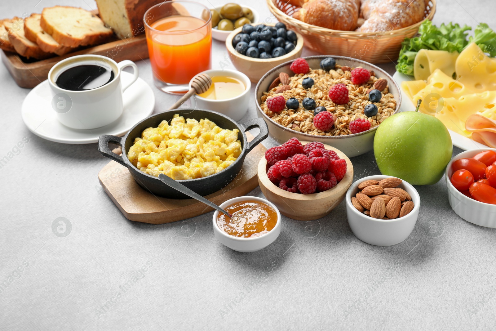 Photo of Tasty breakfast. Many different food and drinks on grey textured table