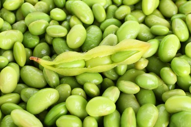 Photo of Raw green edamame pod on soybeans as background, top view