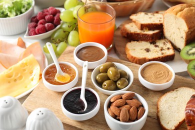 Photo of Different meals served for breakfast on white table, closeup. Buffet menu