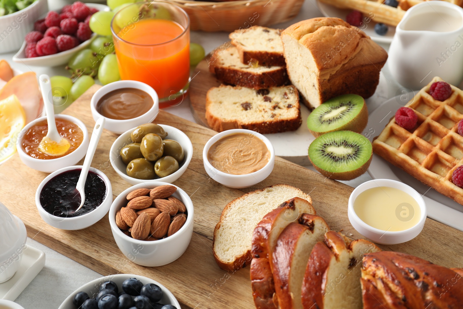 Photo of Different meals served for breakfast on white table, closeup. Buffet menu