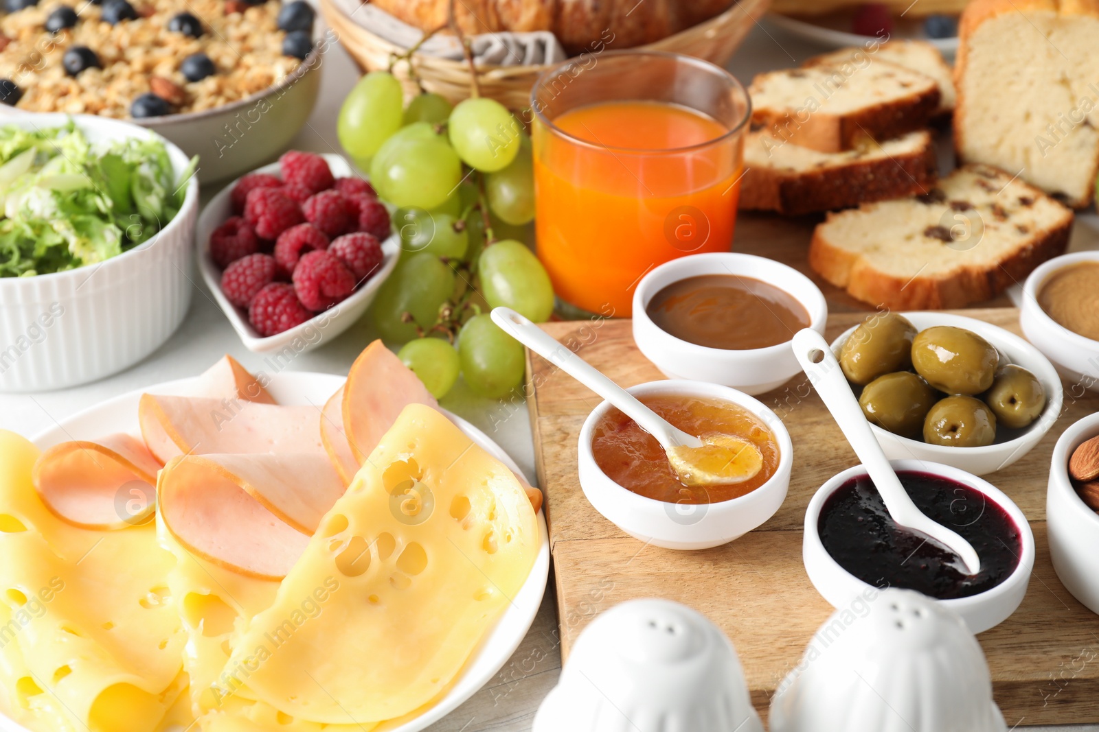 Photo of Different meals served for breakfast on white table, closeup. Buffet menu