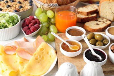 Photo of Different meals served for breakfast on white table, closeup. Buffet menu