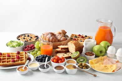 Different meals served for breakfast on white table