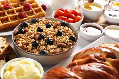 Photo of Different meals served for breakfast on white table, closeup. Buffet menu