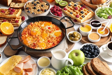 Photo of Different meals served for breakfast on white table