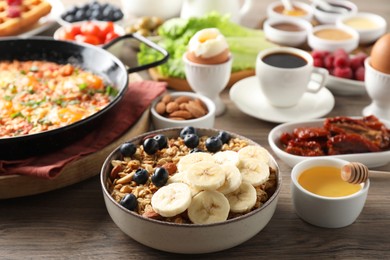 Photo of Different meals served for breakfast on wooden table