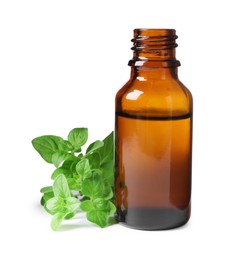 Photo of Essential oil in bottle and oregano leaves isolated on white