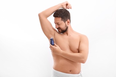 Man applying roll-on deodorant on white background