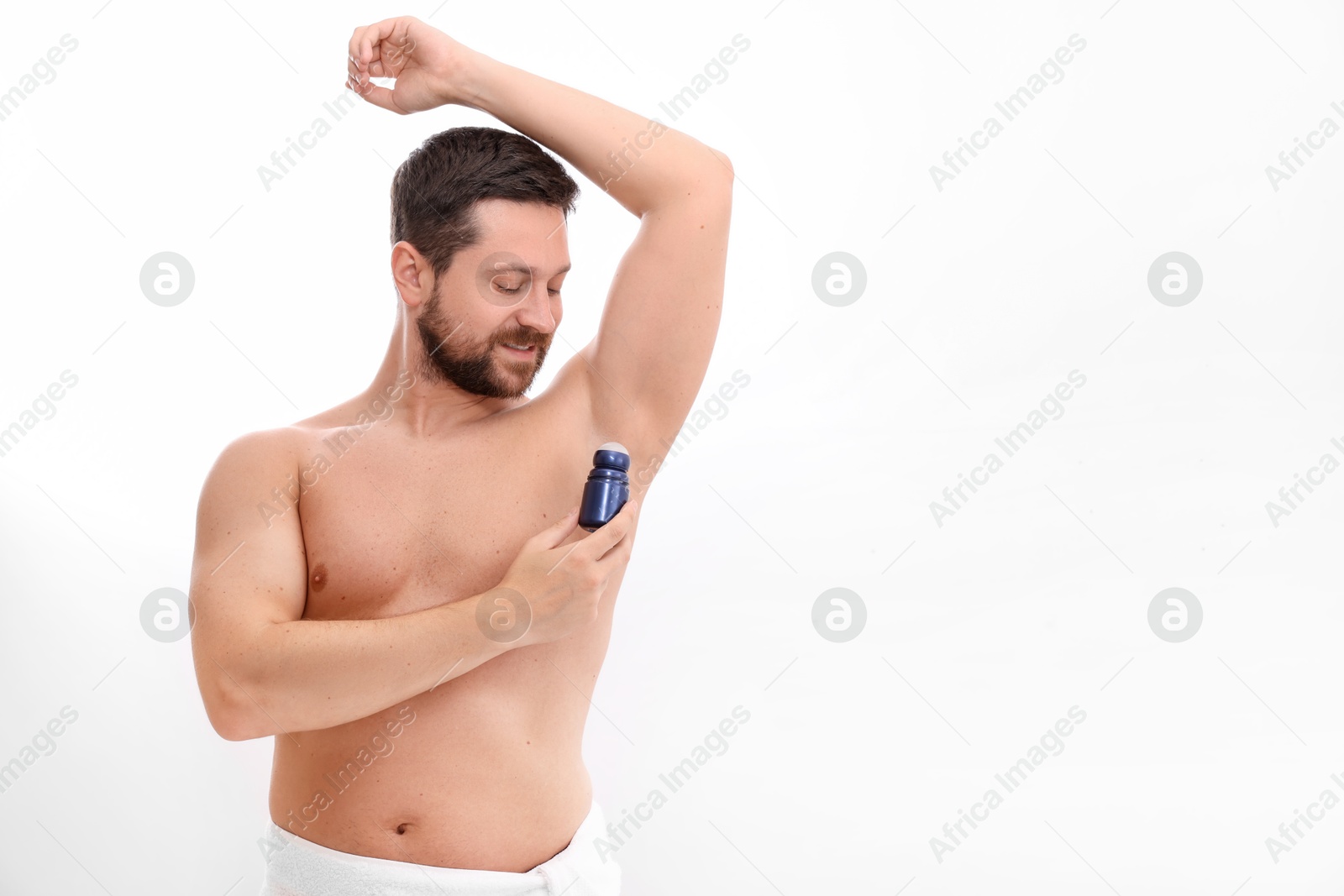 Photo of Man applying roll-on deodorant on white background. Space for text