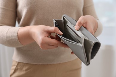 Photo of Woman with empty wallet indoors, closeup view