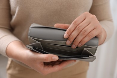 Photo of Woman with empty wallet indoors, closeup view