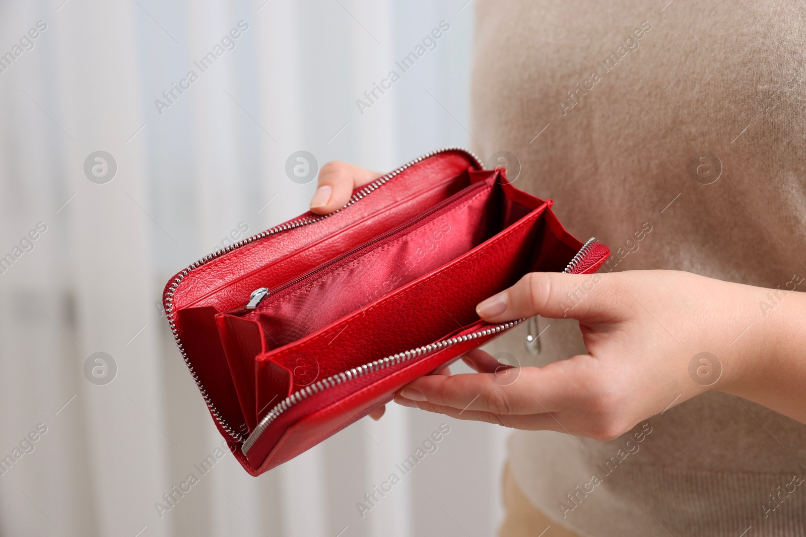 Photo of Woman with empty wallet indoors, closeup view