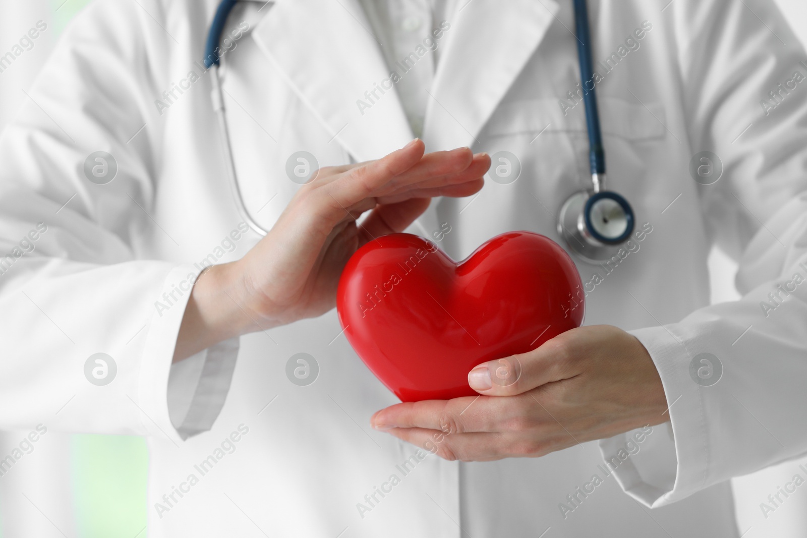 Photo of Doctor with red heart in clinic, closeup