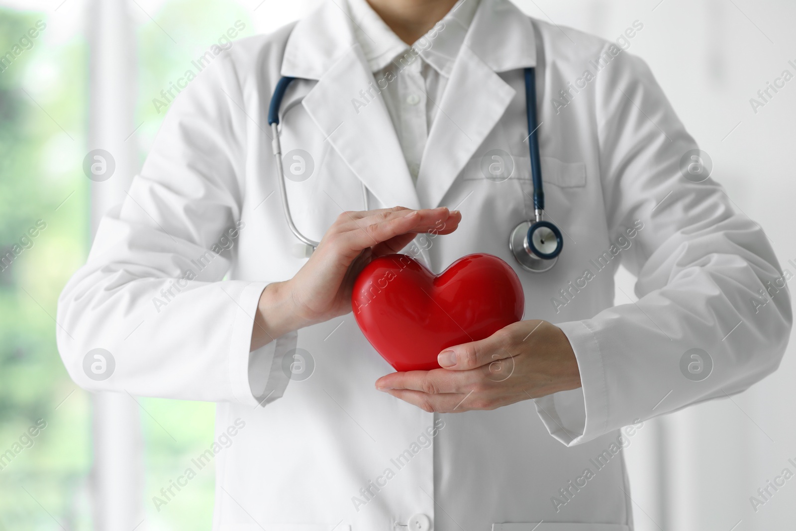 Photo of Doctor with red heart in clinic, closeup