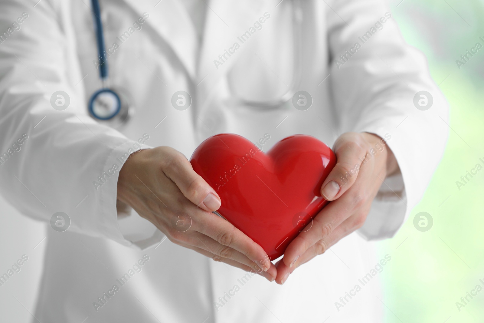 Photo of Doctor with red heart in clinic, closeup