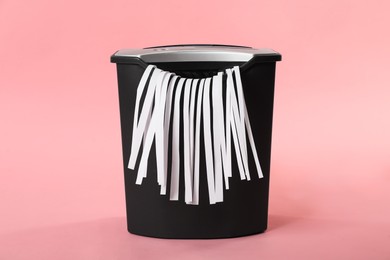 Photo of Shredder with paper strips on pink background