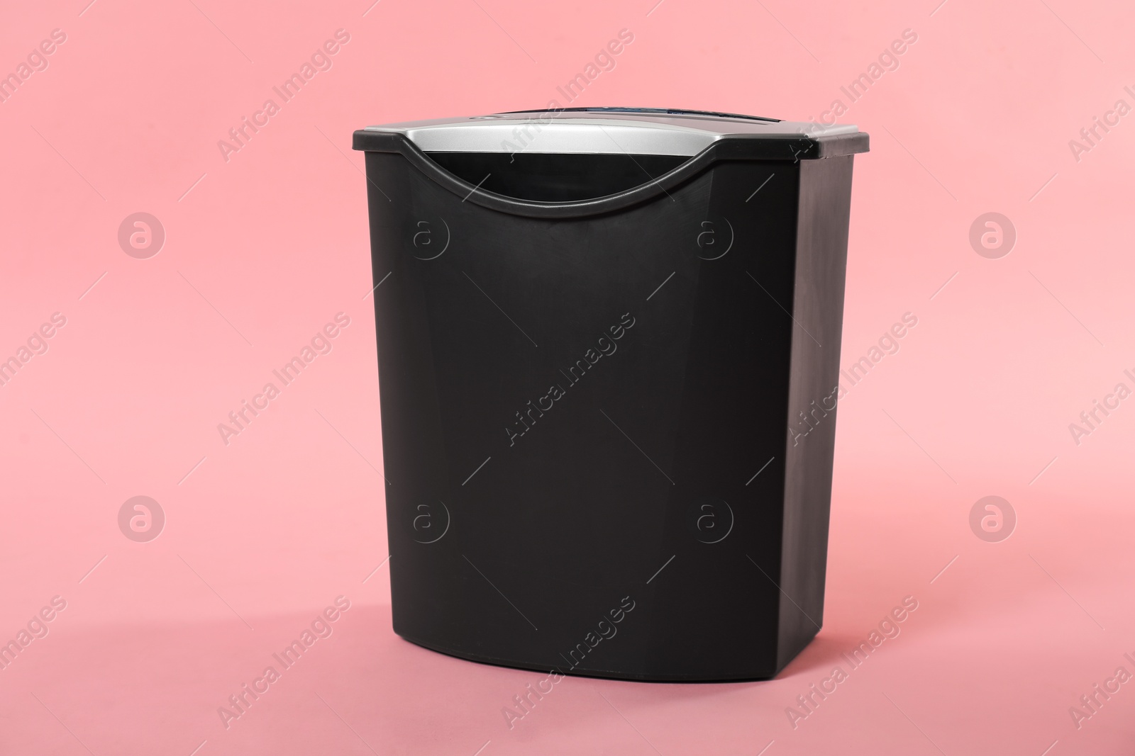 Photo of Paper shredder with basket on pink background