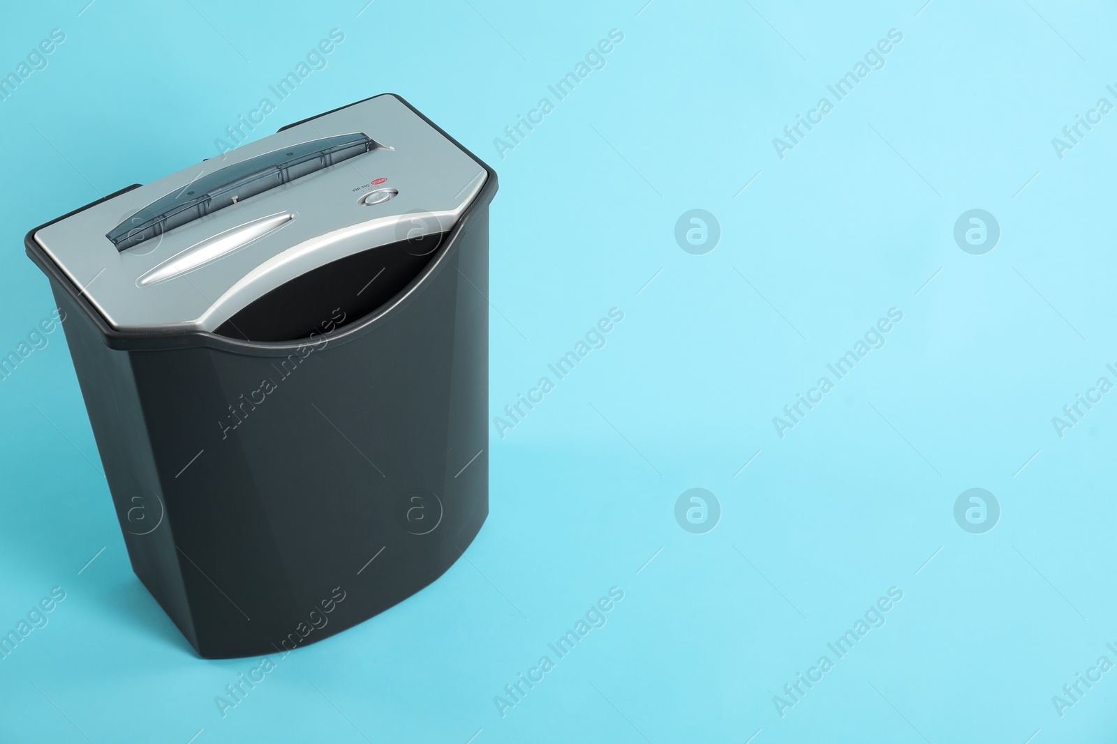 Photo of One paper shredder on light blue background, space for text