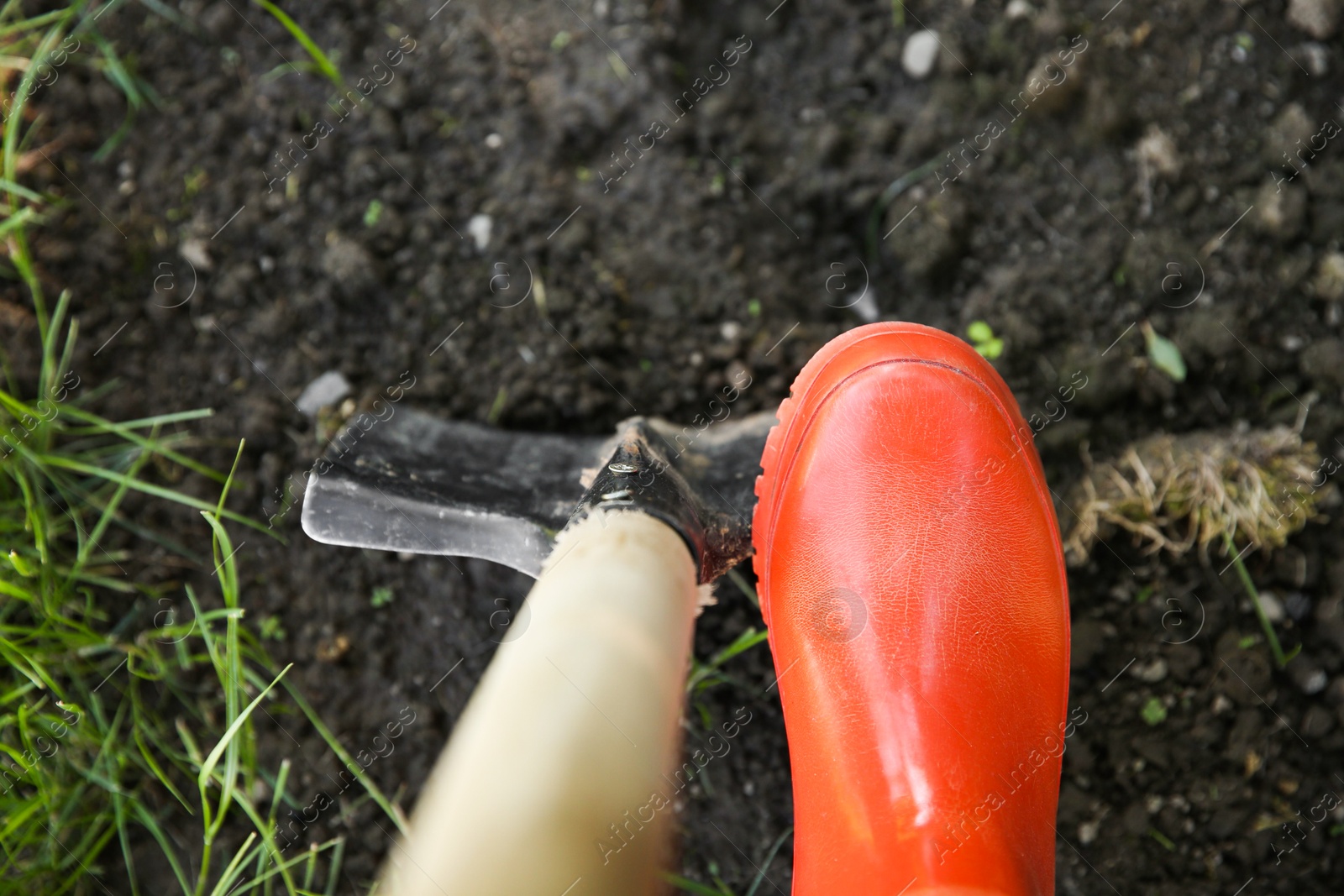 Photo of Farmer digging soil with shovel, above view