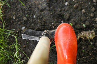 Photo of Farmer digging soil with shovel, above view