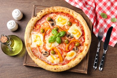 Photo of Delicious vegetarian pizza served on wooden table, flat lay