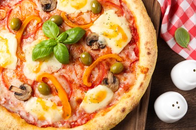 Photo of Delicious vegetarian pizza on wooden table, top view