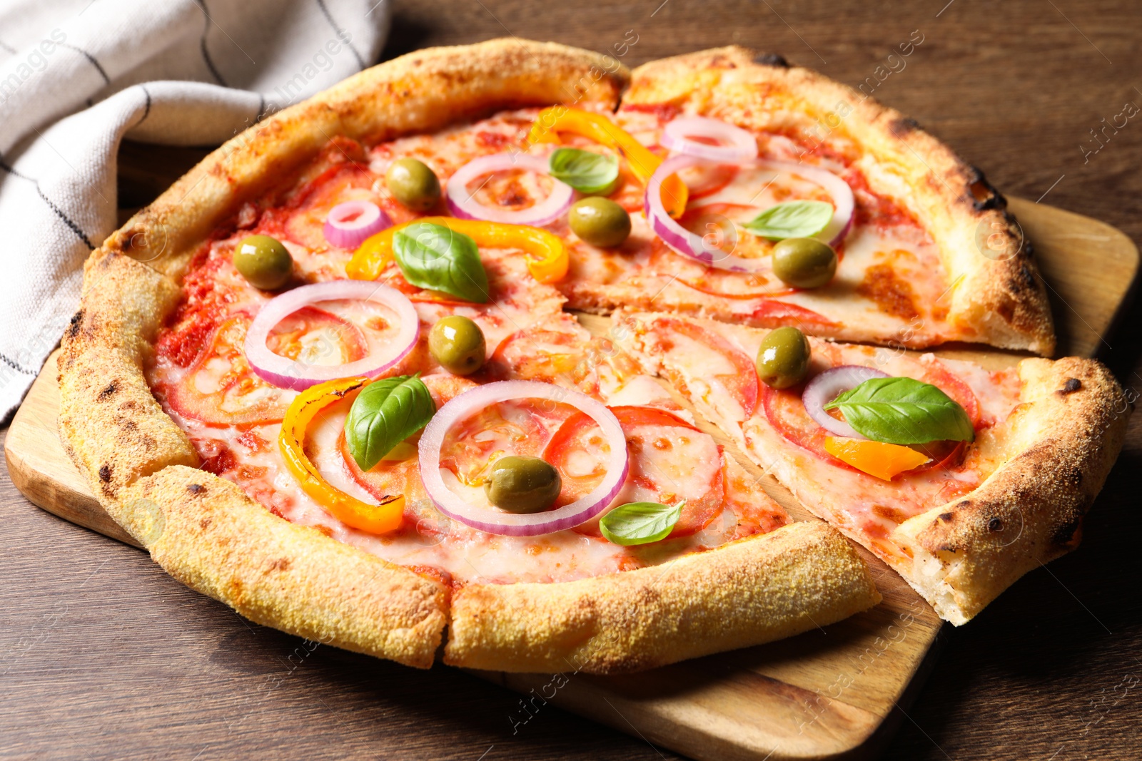 Photo of Cut delicious vegetarian pizza on wooden table, closeup