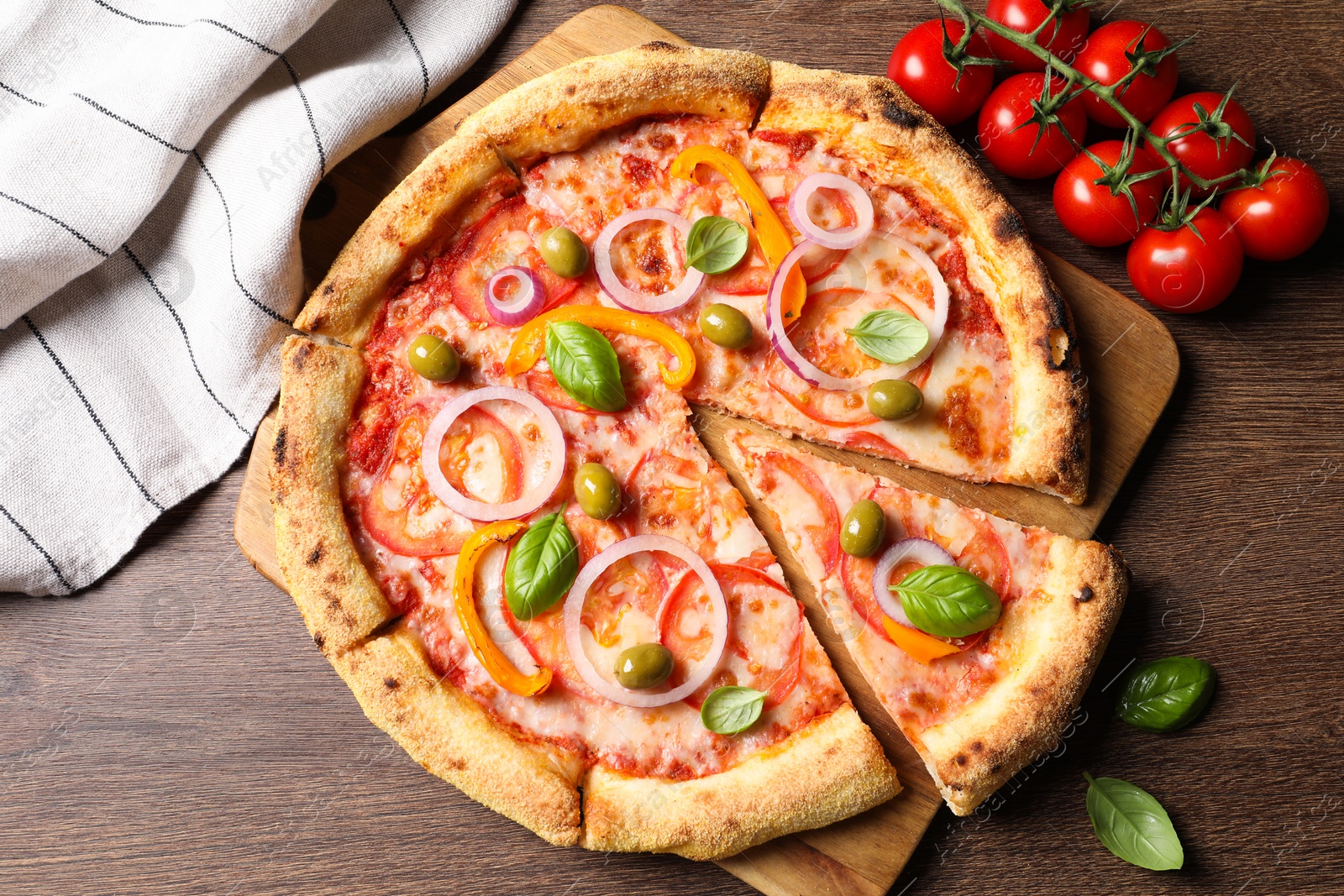 Photo of Delicious vegetarian pizza and tomatoes on wooden table, flat lay