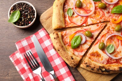 Photo of Delicious vegetarian pizza served on wooden table, flat lay