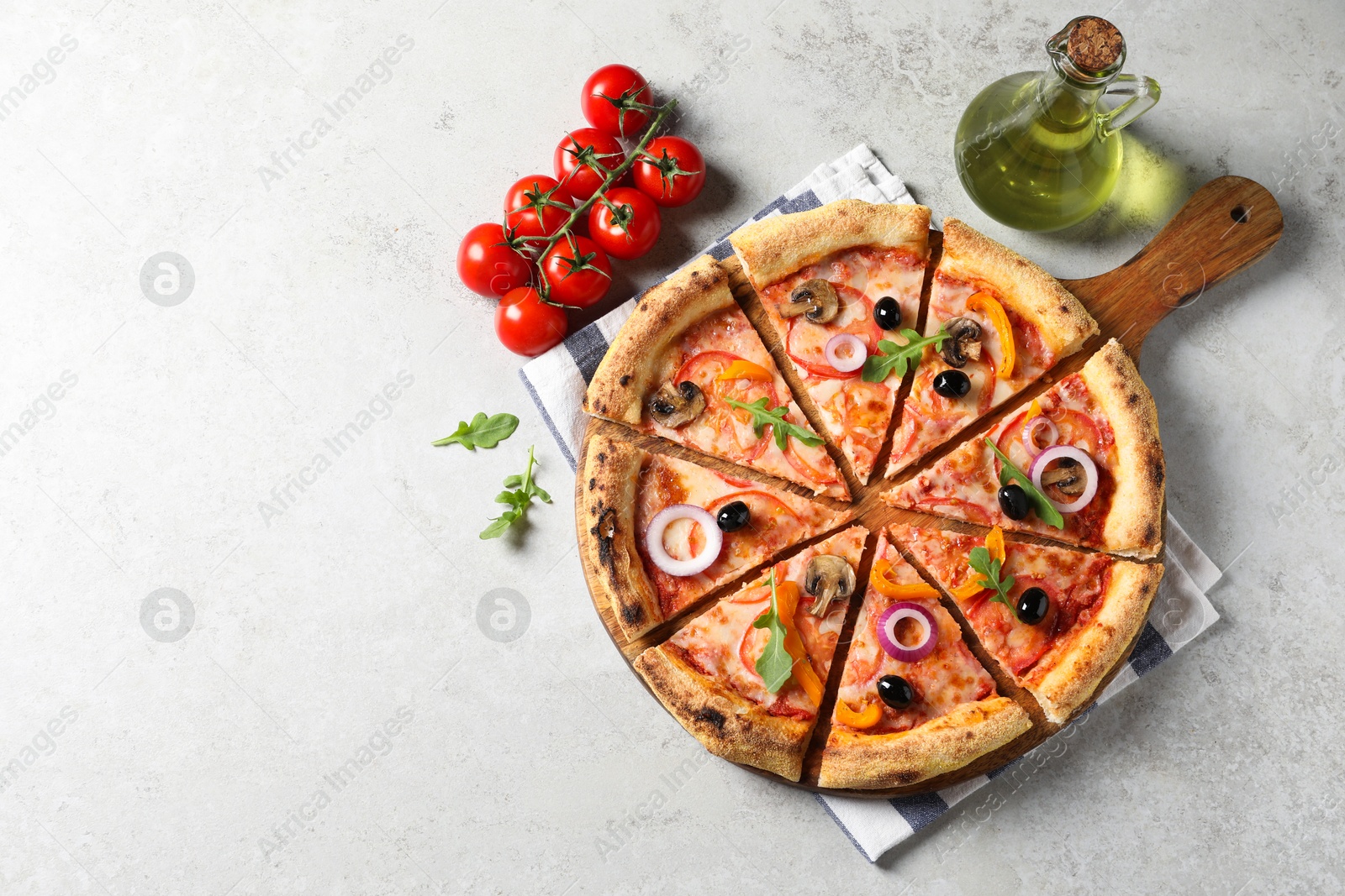 Photo of Cut delicious vegetarian pizza, oil and tomatoes on light table, top view. Space for text