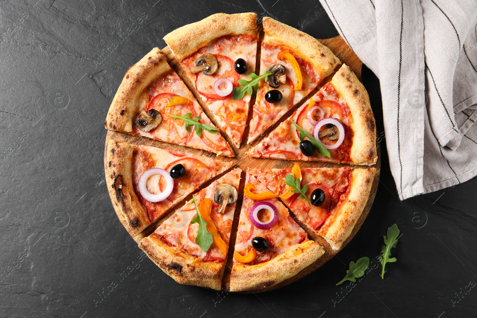 Photo of Cut delicious vegetarian pizza on black table, top view