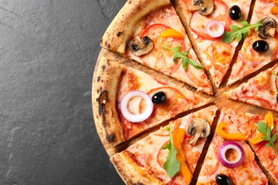 Photo of Cut delicious vegetarian pizza on black table, top view