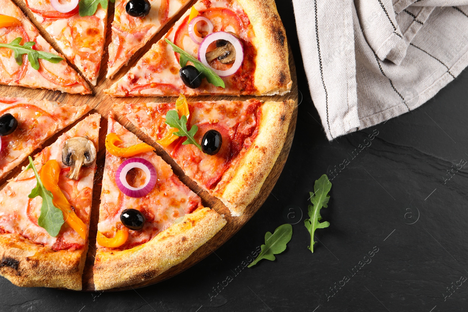 Photo of Cut delicious vegetarian pizza on black table, top view