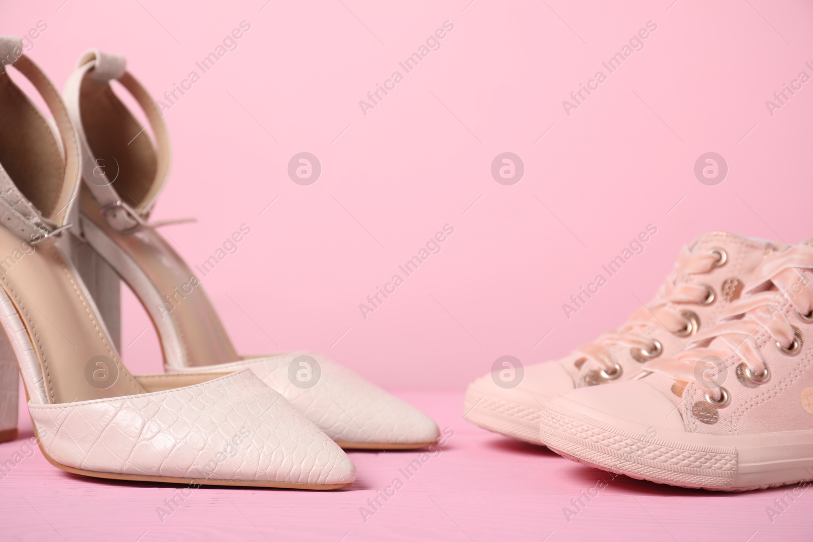 Photo of Big and small shoes on pink background