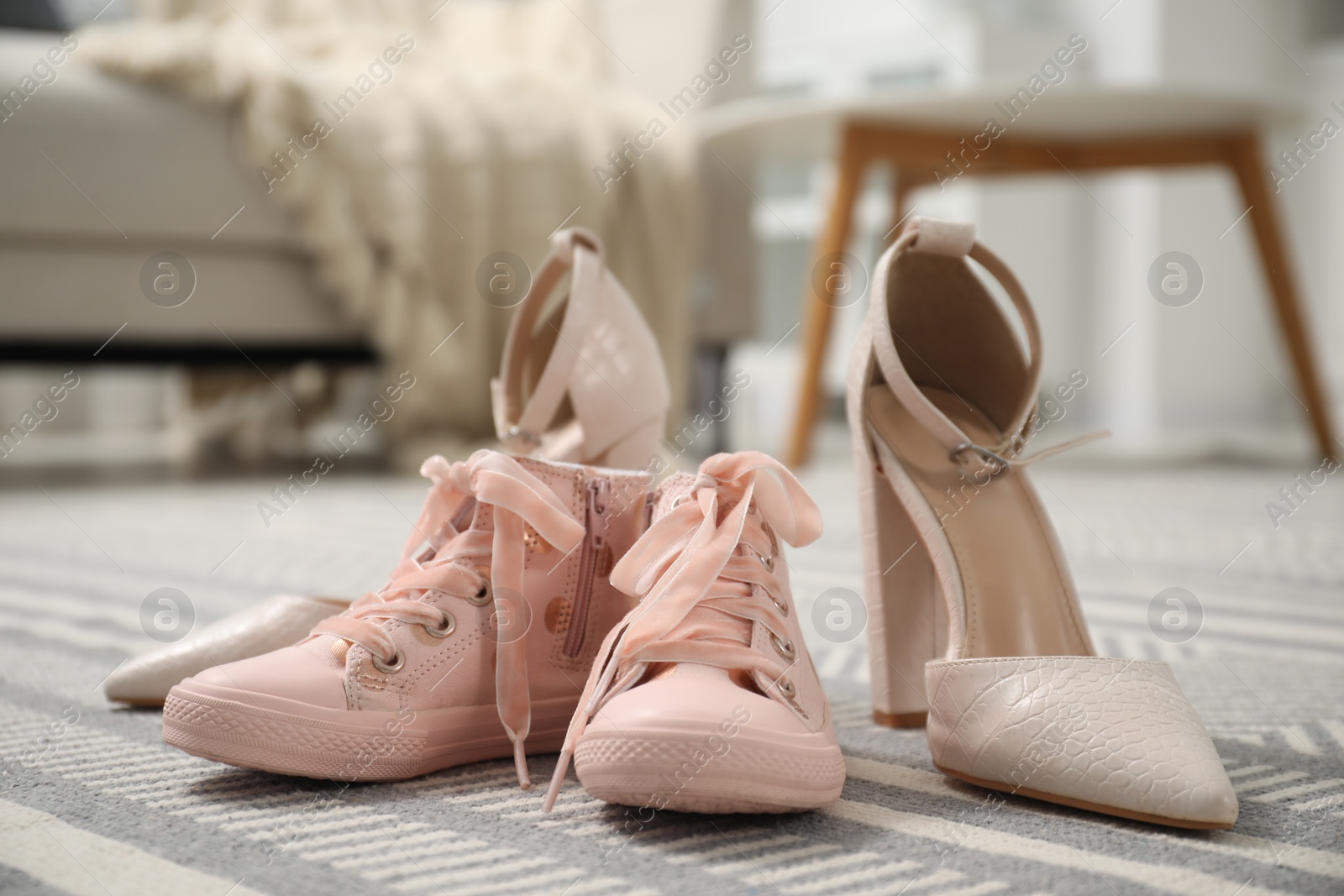 Photo of Big and small shoes on carpet indoors