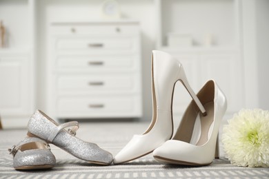 Photo of Big and small shoes on carpet indoors