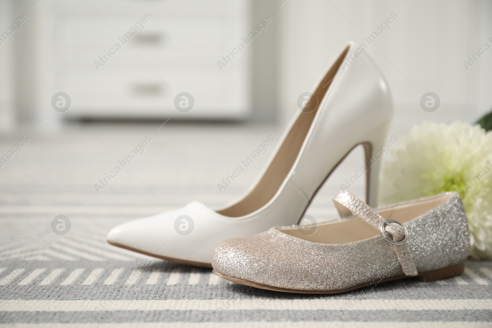 Photo of Big and small shoes on carpet indoors