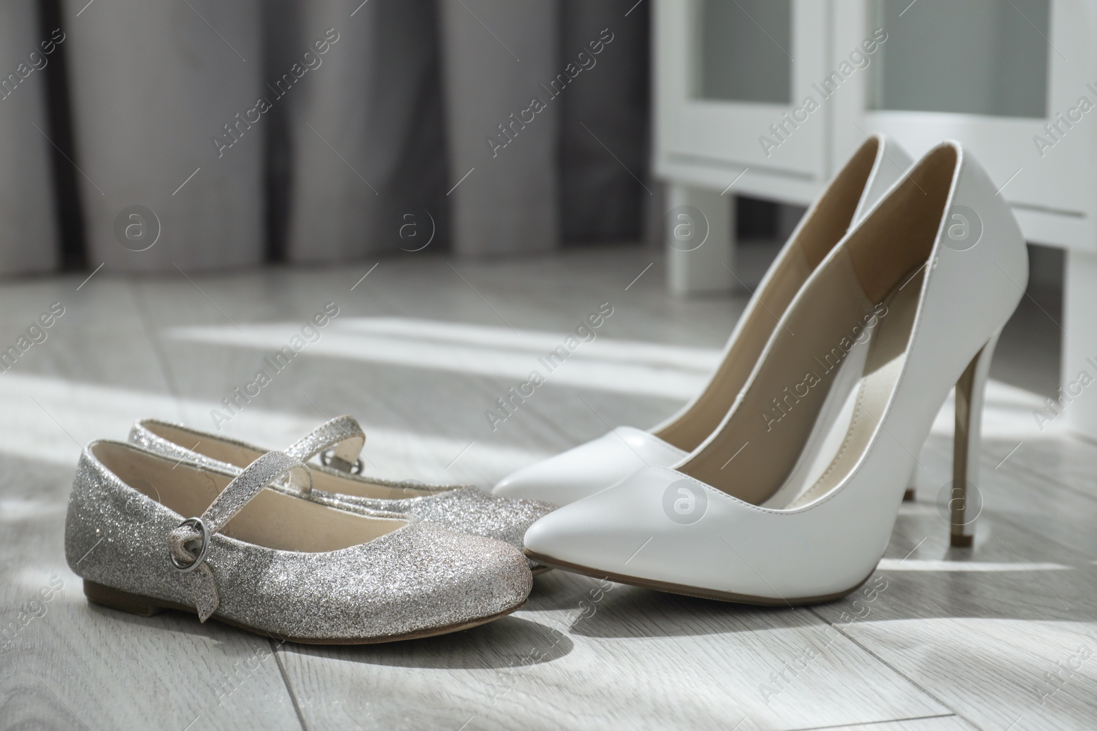 Photo of Big and small shoes on floor indoors