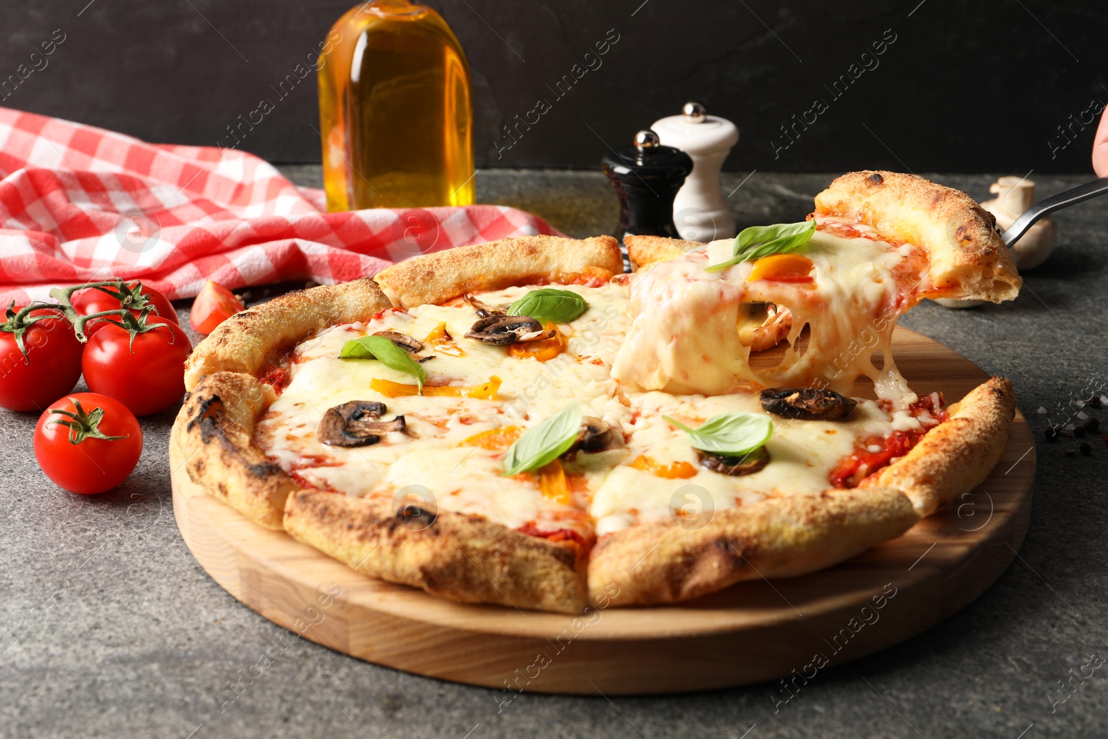 Photo of Taking piece of delicious vegetarian pizza at grey table, closeup