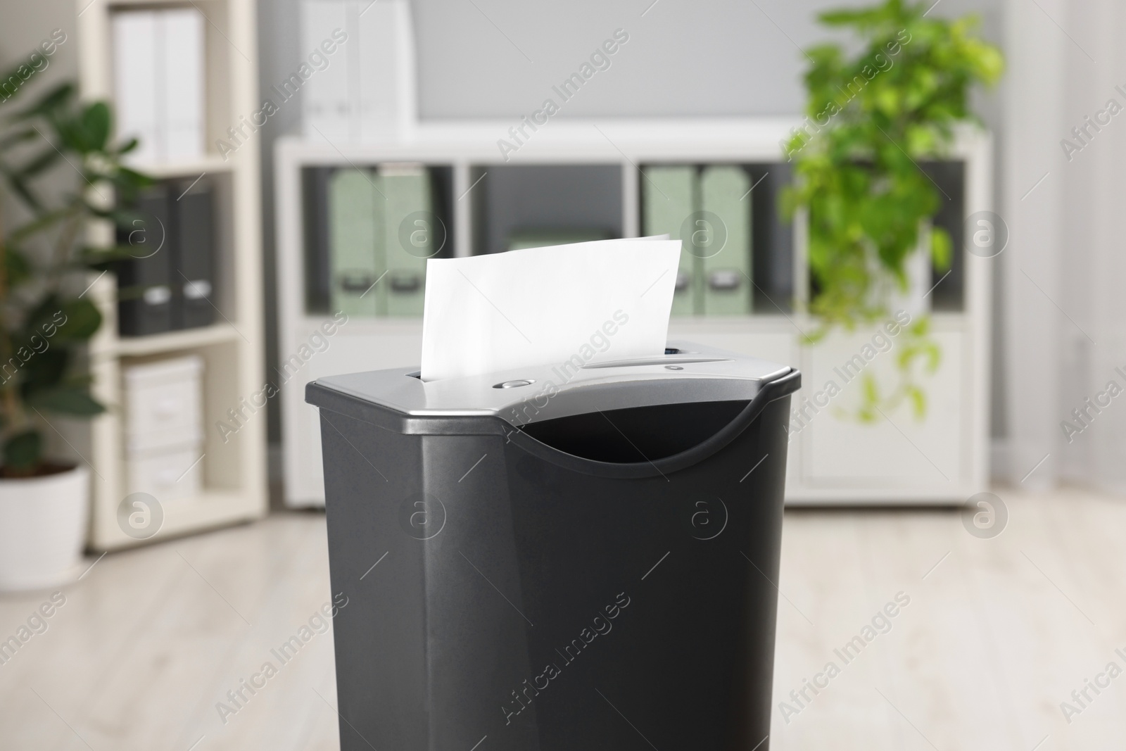 Photo of Destroying sheets of paper with shredder in office