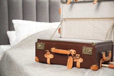 Photo of Open empty suitcase for travelling on bed indoors, closeup