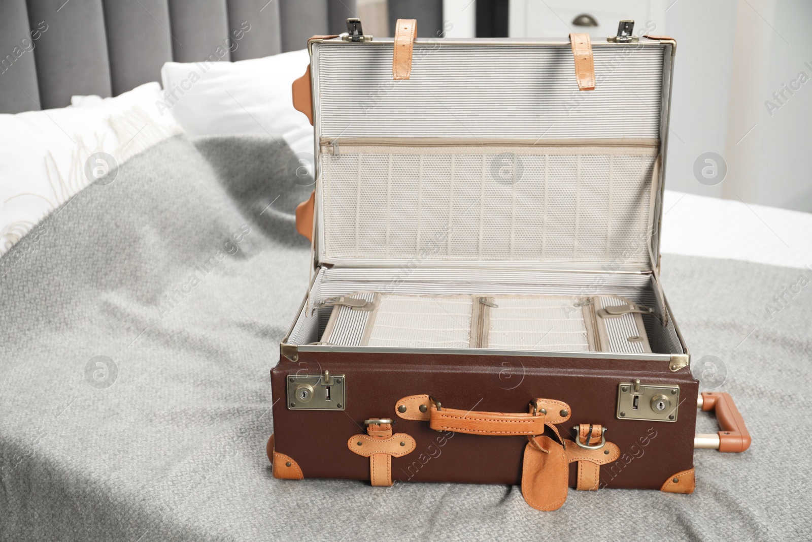 Photo of Open empty suitcase for travelling on bed indoors